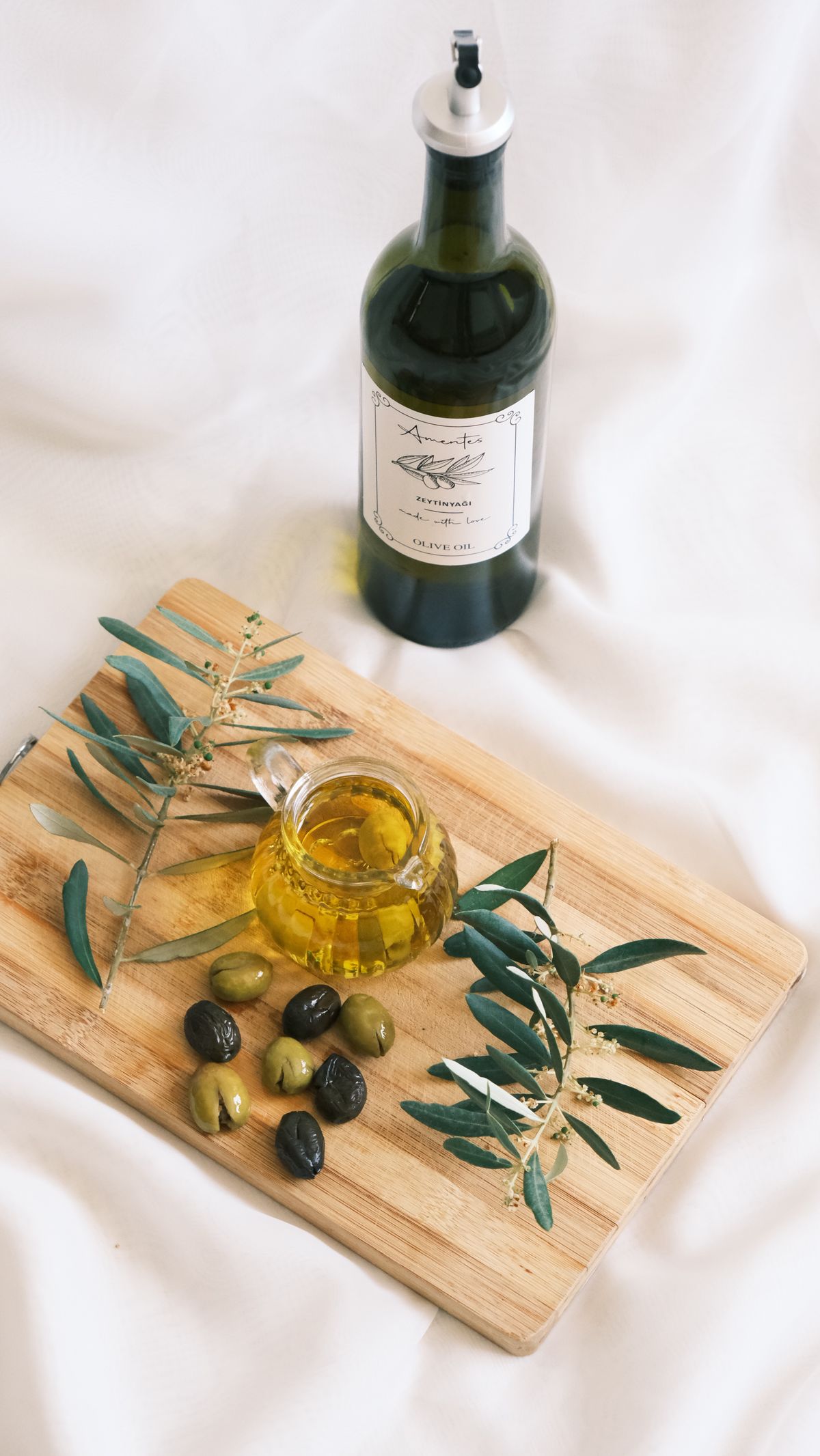 Zeytinyağı şişesi ve zeytin dalları